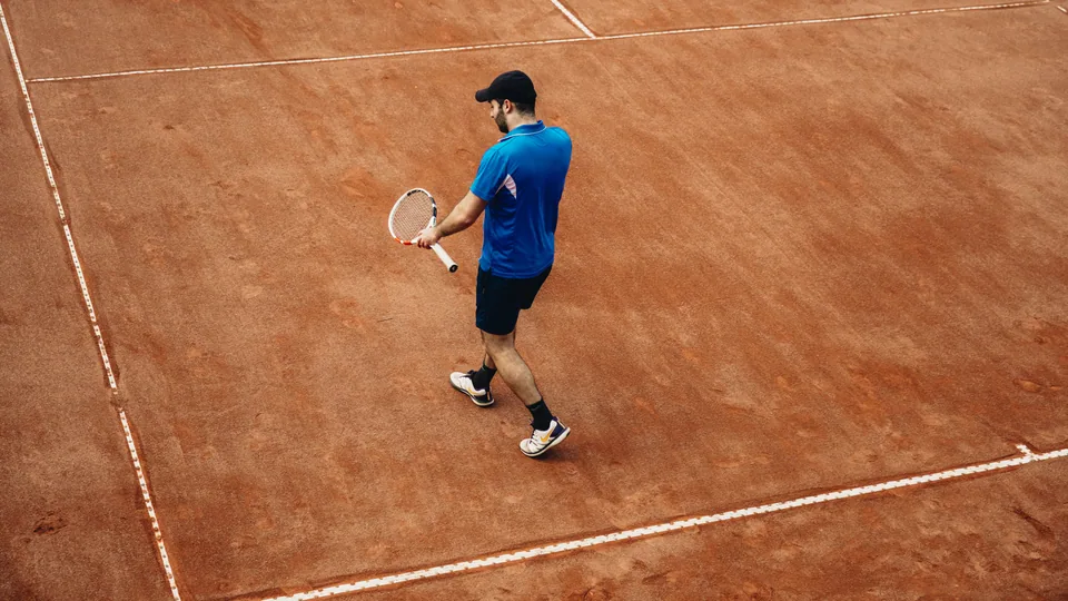 Tennisspelare i slagögonblicket på banan